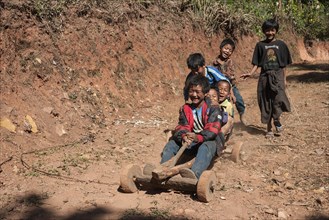 Children from Palaung tribe ride homemade vehicle in Kalaw