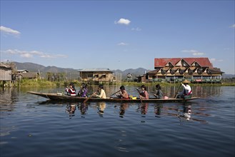 Local women in a wooden boat paddling on Inle Lake