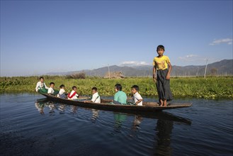 Local children in a wooden boat on Inle Lake
