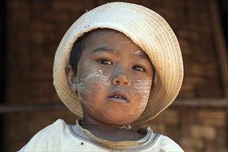 Local girl with hat and Thanaka paste on the face