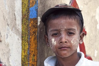 Local boy with cap and Thanaka paste on the face