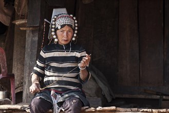 Native woman from the Akha tribe in typical clothes and typical headgear