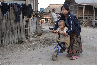 Local girl with small child on a bicycle