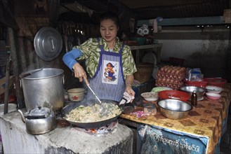 Native woman preparing food at a food stall in the market