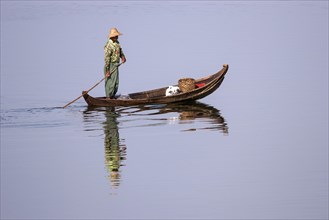 Local man on a wooden boat on the Taungthaman lake