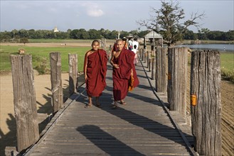Two Buddhist monks walking on the U Bein Bridge