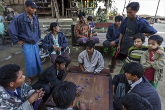Local men sitting around a game table playing a board game