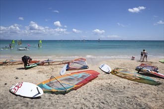 Windsurfing boards and sails lying on the beach