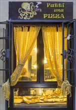 Window of a restaurant with a curtain made of pasta