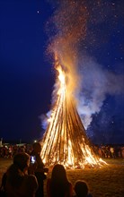 People standing around a Sonnwendfeuer bonfire