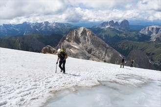 Climbers crossing snow covered area at the summit Punta Penia