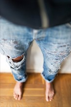 Young girl in fashionable torn jeans with holes