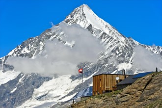 The Taschhutte in front of the snow-covered summit of the Weisshorn