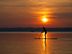 Paddler on a standup board at sunset