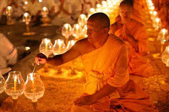 Monk lights candle