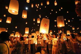 People letting sky lanterns rise