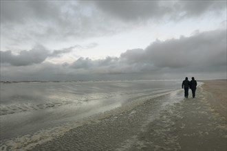Walkers in bad weather on the beach of the North Sea island Langeoog