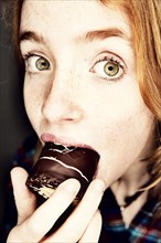 Girl eating a chocolate-coated marshmallow