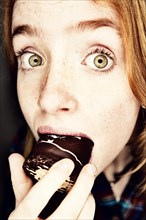 Girl eating a chocolate-coated marshmallow