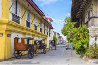 Horse-drawn Kalesa carriages waiting in front of historic colonial-era Syquia Mansion in Vigan City