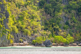 Small native village of thatched huts on the coast of Coron Island