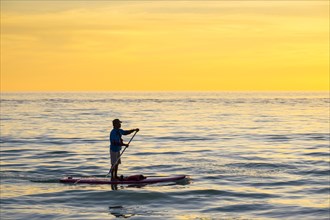 A man on a stand-up-paddleboard