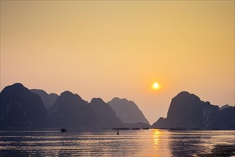 Sunset over karst mountains in Halong Bay
