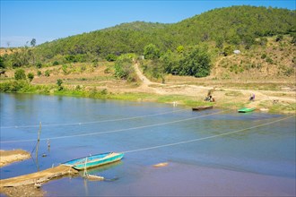 Small boats provide ferry service over a river in rural Vietnam