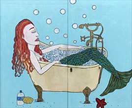 Redhead mermaid in a bathtub
