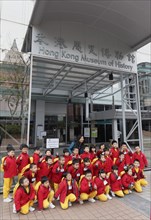 Asian kids in school uniforms in front of the Hong Kong Museum of History