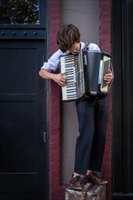 A busker plays an accordion