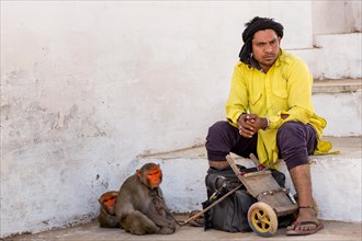 A man with his painted rhesus macaque