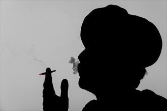 Silhouette of a Rajasthani man with a turban smoking a cigarette