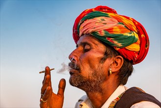 Portrait of Rajasthani man with turban smoking a cigarette