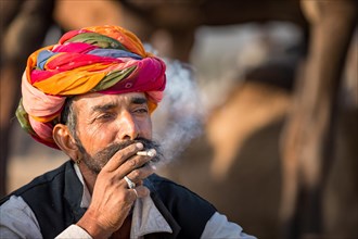 Portrait of Rajasthani man with turban smoking a cigarette