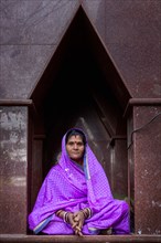 Elderly woman sitting in front of a temple in Pushkar