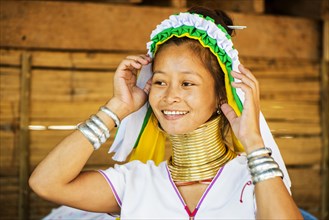 Young Kayan hill tribe woman does her hair in the morning