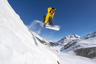 Snowboarder jumping in deep snow