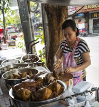 Street vendor preparing chicken at food stall