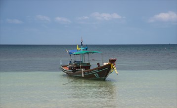Colourful long-tail boat in turquoise sea