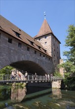 Kettensteg chain-hung bridge and Fronveste with Schlayerturm tower above river Pegnitz