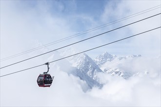 Gondola in the fog in front of mountain panorama