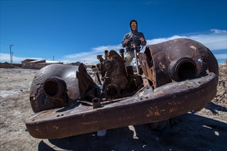 Young man sitting in rusty old car