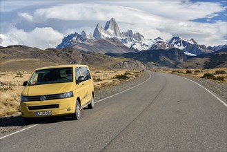 VW bus on the road to El Chalten in front of a mountain range with striking Monte Fitz Roy