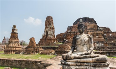 Dilapidated temple complex with large stupa and Buddha statue