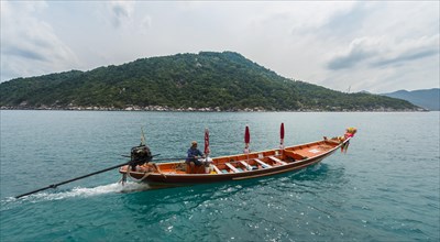 Thai man steering a longtail boat