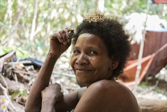 Woman of the Orang Asil tribe sitting in the jungle