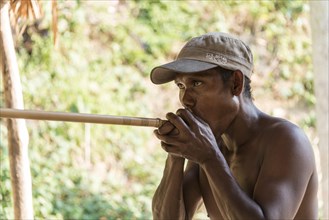 Orang Asli native man shooting a blowgun
