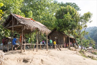 People sitting in front of wooden huts