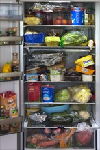 Crammed refrigerator with various foods